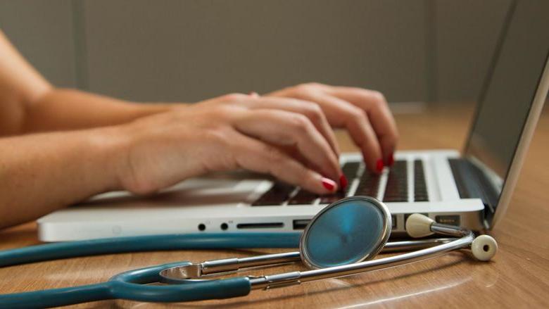 Medical examiner adding data on a laptop